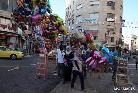A Palestinian vendor sells ballons in the market during preparations for the Eid Al-Fitr feast in the West Bank city of Ramallah, on Aug 16, 2012, as Muslims over the world prepare to celebrate Eid al-Fitr, a three day h...