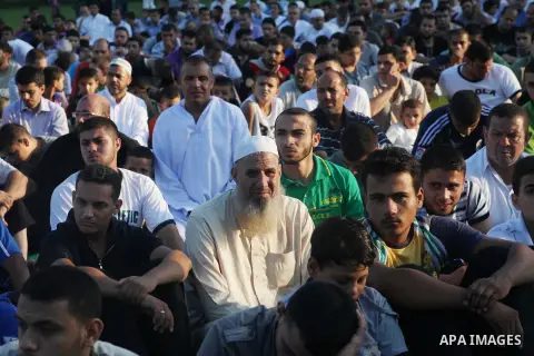 Palestinians attend Eid al-Fitr prayers at the Palestine Stadium in Gaza City August 19, 2012. Eid al-Fitr marks the end of the Muslim holy month of Ramadan. Photo by Ashraf Amra