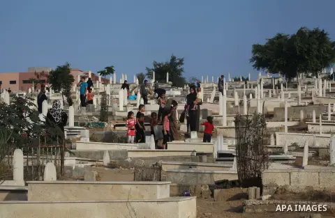Palestinians visit their relative's graves at a cemetery in Gaza City on the first day of Eid Al-Fitr on Aug. 19, 2012. Eid-Al-Fitr marks the end of the Muslim holy month of Ramadhan. Photo by Ashraf Amra