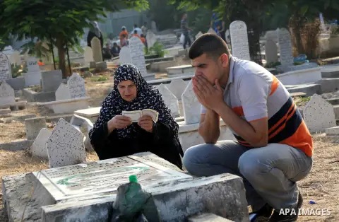Palestinians visit their relative's graves at a cemetery in Gaza City on the first day of Eid Al-Fitr on Aug. 19, 2012. Eid-Al-Fitr marks the end of the Muslim holy month of Ramadhan. Photo by Ashraf Amra