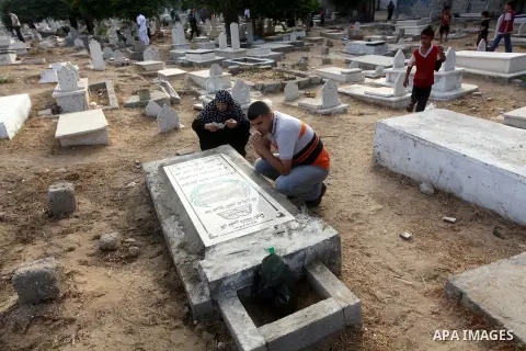 Palestinians visit their relative's graves at a cemetery in Gaza City on the first day of Eid Al-Fitr on Aug. 19, 2012. Eid-Al-Fitr marks the end of the Muslim holy month of Ramadhan. Photo by Ashraf Amra