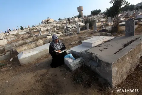 Palestinians visit their relative's graves at a cemetery in Gaza City on the first day of Eid Al-Fitr on Aug. 19, 2012. Eid-Al-Fitr marks the end of the Muslim holy month of Ramadhan. Photo by Ashraf Amra