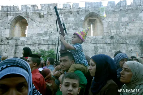 A Palestinian child hold his toy in front of al-Aqsa mosque compound during the Eid al-Fitr prayers in Jerusalem's Old City, Sunday, Aug. 19, 2012. Muslims are celebrating the festival of Eid al-Fitr which marks the end...