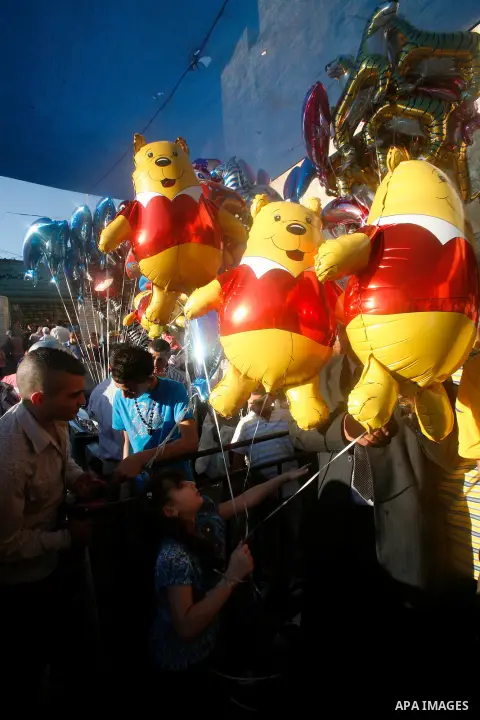 Palestinian hold ballons in front of the Dome of the Rock mosque during the Eid al-Fitr prayers at al-Aqsa mosque in Jerusalem's Old City, Sunday, Aug. 19, 2012. Muslims are celebrating the festival of Eid al-Fitr which...