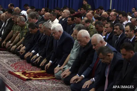 Palestinian President Mahmoud Abbas and his Prime Minister Salam Fayyad attend the early morning Eid Al-Fitr prayer at the Palestinian Authority headquarters in the West Bank city of Ramallah on Aug. 19, 2012 . Muslims o...