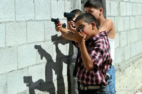 Palestinian children play with a toy gun on the Second day of Eid al-Fitr in the West Bank city of Nablus, Aug. 20, 2012. which marks the end of the Muslim fasting month of Ramadan. Eid, one of the most important holiday...