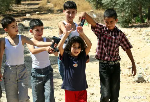 Palestinian children play with a toy gun on the Second day of Eid al-Fitr in the West Bank city of Nablus, Aug. 20, 2012. which marks the end of the Muslim fasting month of Ramadan. Eid, one of the most important holiday...