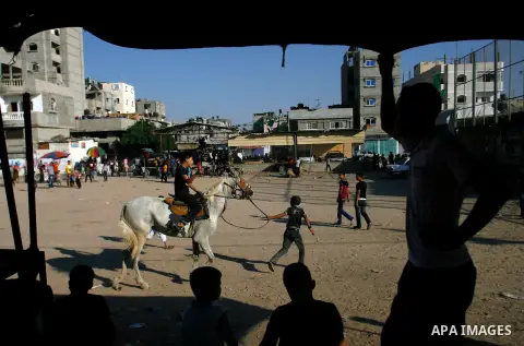 Palestinian children play during the Second day of Eid al-Fitr in Rafah in the southern of Gaza strip, Aug. 20, 2012. which marks the end of the Muslim fasting month of Ramadan. Eid, one of the most important holidays in...