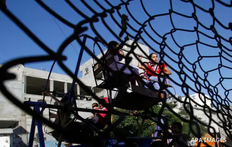 Palestinian children play during the Second day of Eid al-Fitr in Rafah in the southern of Gaza strip, Aug. 20, 2012. which marks the end of the Muslim fasting month of Ramadan. Eid, one of the most important holidays in...