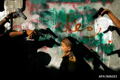 Palestinian children play with a gun toy on the Second day of Eid al-Fitr in Rafah in the southern of Gaza strip, Aug. 20, 2012. which marks the end of the Muslim fasting month of Ramadan. Eid, one of the most important...