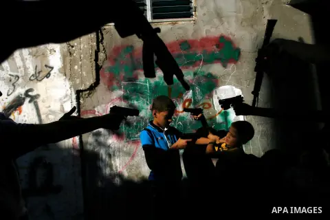 Palestinian children play with a gun toy on the Second day of Eid al-Fitr in Rafah in the southern of Gaza strip, Aug. 20, 2012. which marks the end of the Muslim fasting month of Ramadan. Eid, one of the most important...