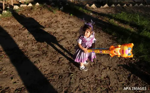 A Palestinian girl carries a ballon at a park during the Second day of Eid al-Fitr in Gaza city, Aug. 20, 2012. which marks the end of the Muslim fasting month of Ramadan. Eid, one of the most important holidays in the M...