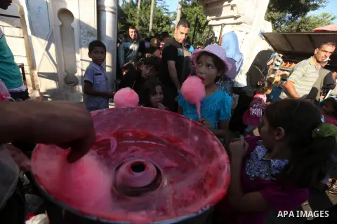 Palestinian children buy cotton candy in front of a park during the Second day of Eid al-Fitr in Gaza city, Aug. 20, 2012. which marks the end of the Muslim fasting month of Ramadan. Eid, one of the most important holida...