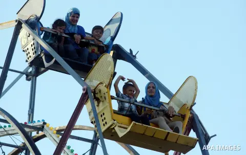 Palestinians enjoy the second day of Eid al-Fitr in an amusement park, in the West Bank city of Ramallah, Monday, Aug. 20, 2012. Eid, one of the most important holidays in the Muslim world, is marked with prayers, family...