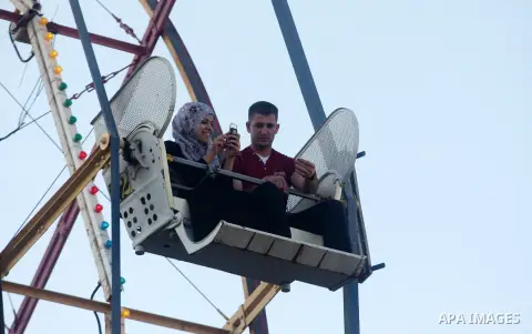 Palestinians enjoy the second day of Eid al-Fitr in an amusement park, in the West Bank city of Ramallah, Monday, Aug. 20, 2012. Eid, one of the most important holidays in the Muslim world, is marked with prayers, family...