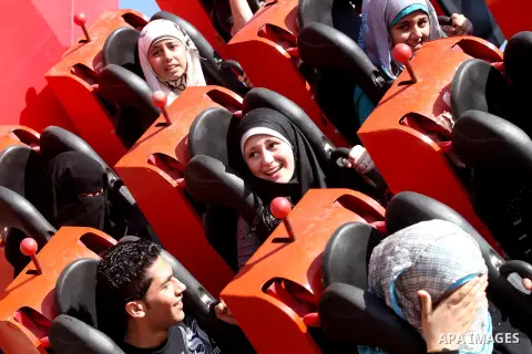 Palestinians enjoy a ride in an amusement park on the third day of Eid al-Fitr, marking the end of Islam's fasting holy month of Ramadan, in Gaza City on August 21, 2012. Photo by Majdi Fathi