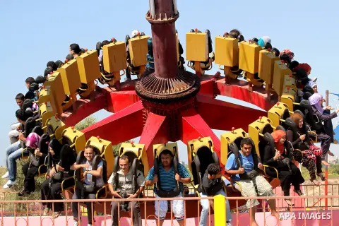 Palestinians enjoy a ride in an amusement park on the third day of Eid al-Fitr, marking the end of Islam's fasting holy month of Ramadan, in Gaza City on August 21, 2012. Photo by Majdi Fathi
