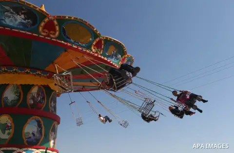 Palestinians enjoy a ride in an amusement park on the third day of Eid al-Fitr, marking the end of Islam's fasting holy month of Ramadan, in Gaza City on August 21, 2012. Photo by Majdi Fathi