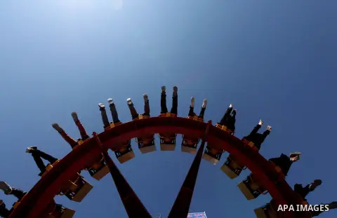 Palestinians enjoy a ride in an amusement park on the third day of Eid al-Fitr, marking the end of Islam's fasting holy month of Ramadan, in Gaza City on August 21, 2012. Photo by Majdi Fathi