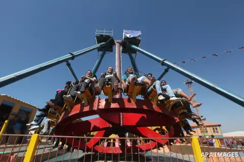 Palestinians enjoy a ride in an amusement park on the third day of Eid al-Fitr, marking the end of Islam's fasting holy month of Ramadan, in Gaza City on August 21, 2012. Photo by Majdi Fathi