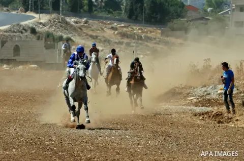 Palestinian jockeys ride their horses during a race in the West Bank city of Nablus on Aug 21, 2012. Hundreds of Palestinians from all over the West Bank gathered to follow the horse race on Tuesday in the northern West...