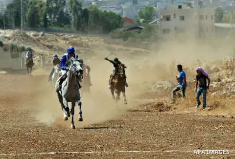 Palestinian jockeys ride their horses during a race in the West Bank city of Nablus on Aug 21, 2012. Hundreds of Palestinians from all over the West Bank gathered to follow the horse race on Tuesday in the northern West...