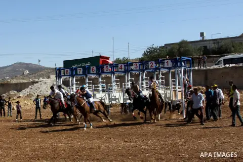 Palestinian jockeys ride their horses during a race in the West Bank city of Nablus on Aug 21, 2012. Hundreds of Palestinians from all over the West Bank gathered to follow the horse race on Tuesday in the northern West...