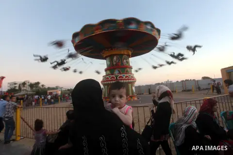 Palestinians enjoy a ride in an amusement park on the third day of Eid al-Fitr, marking the end of Islam's fasting holy month of Ramadan, in Gaza City on August 21, 2012. Photo by Ashraf Amra