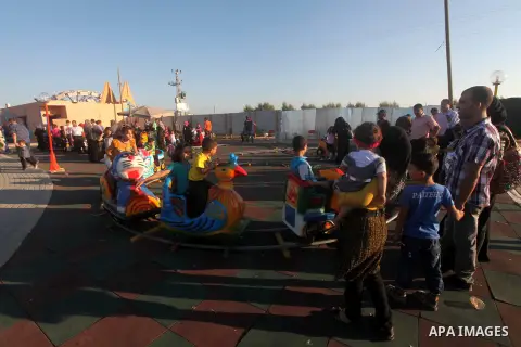 Palestinians enjoy a ride in an amusement park on the third day of Eid al-Fitr, marking the end of Islam's fasting holy month of Ramadan, in Gaza City on August 21, 2012. Photo by Ashraf Amra