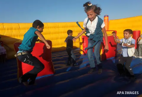 Palestinians enjoy a ride in an amusement park on the third day of Eid al-Fitr, marking the end of Islam's fasting holy month of Ramadan, in Gaza City on August 21, 2012. Photo by Ashraf Amra