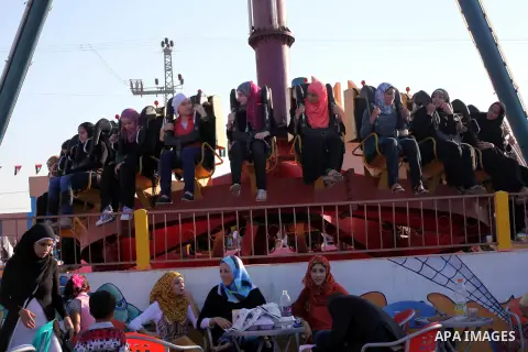 Palestinians enjoy a ride in an amusement park on the third day of Eid al-Fitr, marking the end of Islam's fasting holy month of Ramadan, in Gaza City on August 21, 2012. Photo by Ashraf Amra