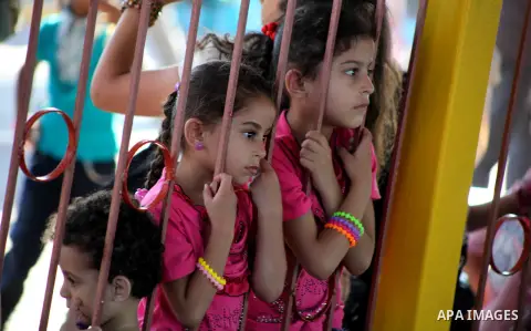 Palestinians enjoy a ride in an amusement park on the third day of Eid al-Fitr, marking the end of Islam's fasting holy month of Ramadan, in Gaza City on August 21, 2012. Photo by Ashraf Amra