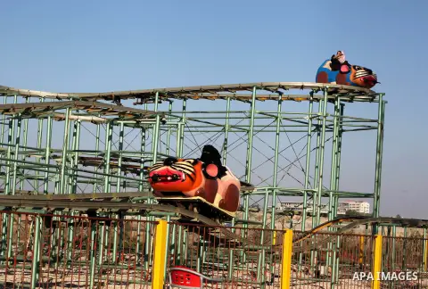 Palestinians enjoy a ride in an amusement park on the third day of Eid al-Fitr, marking the end of Islam's fasting holy month of Ramadan, in Gaza City on August 21, 2012. Photo by Ashraf Amra