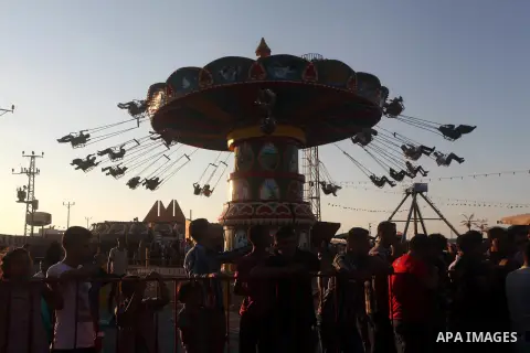 Palestinians enjoy a ride in an amusement park on the third day of Eid al-Fitr, marking the end of Islam's fasting holy month of Ramadan, in Gaza City on August 21, 2012. Photo by Ashraf Amra