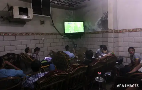 Palestinian youths watch a soccer match for FC Barcelona team against Real Madrid team during a Spanish Supercup at cafe in Deir al-Balah central Gaza Strip, on Aug 23, 2012. Photo by Ashraf Amra