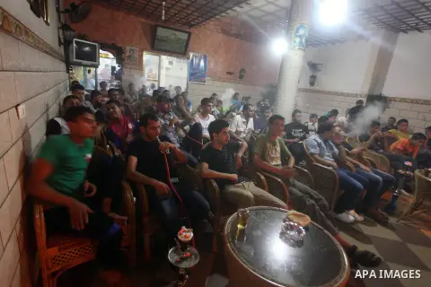 Palestinian youths watch a soccer match for FC Barcelona team against Real Madrid team during a Spanish Supercup at cafe in Deir al-Balah central Gaza Strip, on Aug 23, 2012. Photo by Ashraf Amra