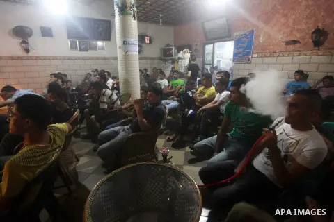 Palestinian youths watch a soccer match for FC Barcelona team against Real Madrid team during a Spanish Supercup at cafe in Deir al-Balah central Gaza Strip, on Aug 23, 2012. Photo by Ashraf Amra
