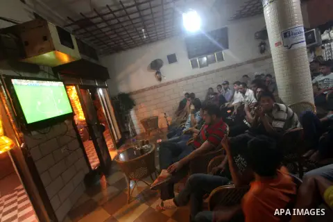 Palestinian youths watch a soccer match for FC Barcelona team against Real Madrid team during a Spanish Supercup at cafe in Deir al-Balah central Gaza Strip, on Aug 23, 2012. Photo by Ashraf Amra