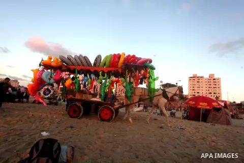 A Palestinian man sells toys on his cart at Gaza beach during Friday holiday in Gaza city, Aug 24, 2012. Gazans escape to the beach and out from their homes during heat wave and power outages. Photo by Ashraf Amra
