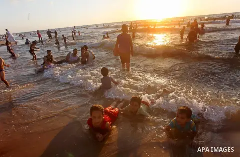 Palestinian children enjoy swimming in the sea at Gaza beach during Friday holiday in Gaza city, Aug 24, 2012. Gazans escape to the beach and out from their homes during heat wave and power outages. Photo by Ashraf Amra