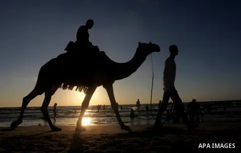 A Palestinian child ride a camel at Gaza beach during Friday holiday in Gaza city, Aug 24, 2012. Gazans escape to the beach and out from their homes during heat wave and power outages. Photo by Ashraf Amra