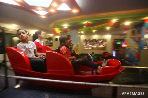 Palestinians children enjoy a ride in an amusement park, during School holidays in Gaza City, Aug. 25, 2012. Photo by Majdi Fathi