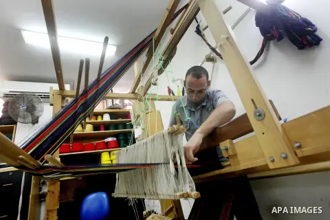 A Deaf Palestinian man works on textile at Atfaluna Society for Deaf Children in Gaza City, on Aug. 26, 2012. The society provides services for about 15,000 deaf youth on education, training programs and income generatin...
