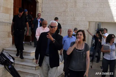 Zahava Gal-On (C-R), head of the Israeli left-wing Meretz party, gesturing as she speaks with Ilan Baruch, a former Israeli ambassador to South Africa, as they pass between Israeli guards after making a statement in the...