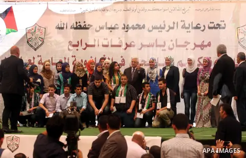Palestinian President Mahmoud Abbas ( Abu Mazen ) takes a picture with a group of high school students during a graduation ceremony in the West Bank city of Ramallah, Sunday, Aug 26, 2012. Photo by Issam Rimawi
