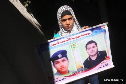 Palestinians hold pictures of their relatives prisoners in Israeli jails as they gather in an activity calling for their liberty at the Red Cross headquarters in Gaza City on Aug. 27, 2012. Photo by Majdi Fathi