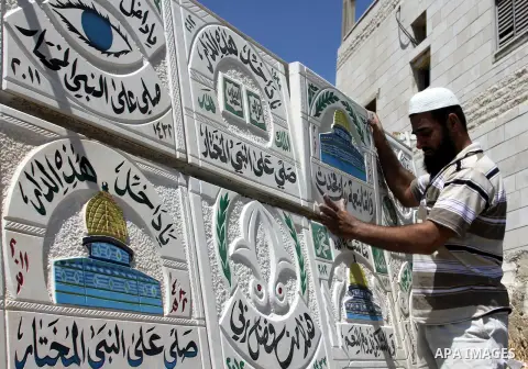 A Palestinian man displays the stones carved out of rock and painted it the Dome of the Rock in order to sell it, in the West Bank City of Nablus, on Aug. 27, 2012. Photo by Nedal Eshtayah