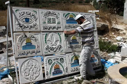 A Palestinian man displays the stones carved out of rock and painted it the Dome of the Rock in order to sell it, in the West Bank City of Nablus, on Aug. 27, 2012. Photo by Nedal Eshtayah