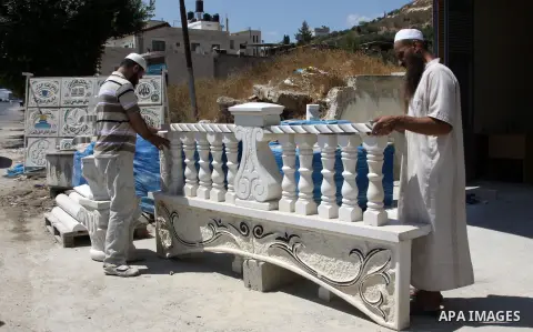 A Palestinian man displays the stones carved out of rock and painted it the Dome of the Rock in order to sell it, in the West Bank City of Nablus, on Aug. 27, 2012. Photo by Nedal Eshtayah