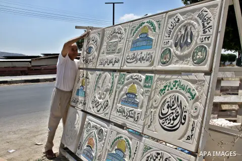 A Palestinian man displays the stones carved out of rock and painted it the Dome of the Rock in order to sell it, in the West Bank City of Nablus, on Aug. 27, 2012. Photo by Nedal Eshtayah